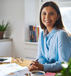 femme souriante assise sur son bureau